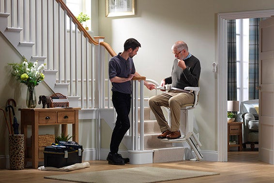 en stairlift technician instruction A stannah engineer assisting a customer and her daughter